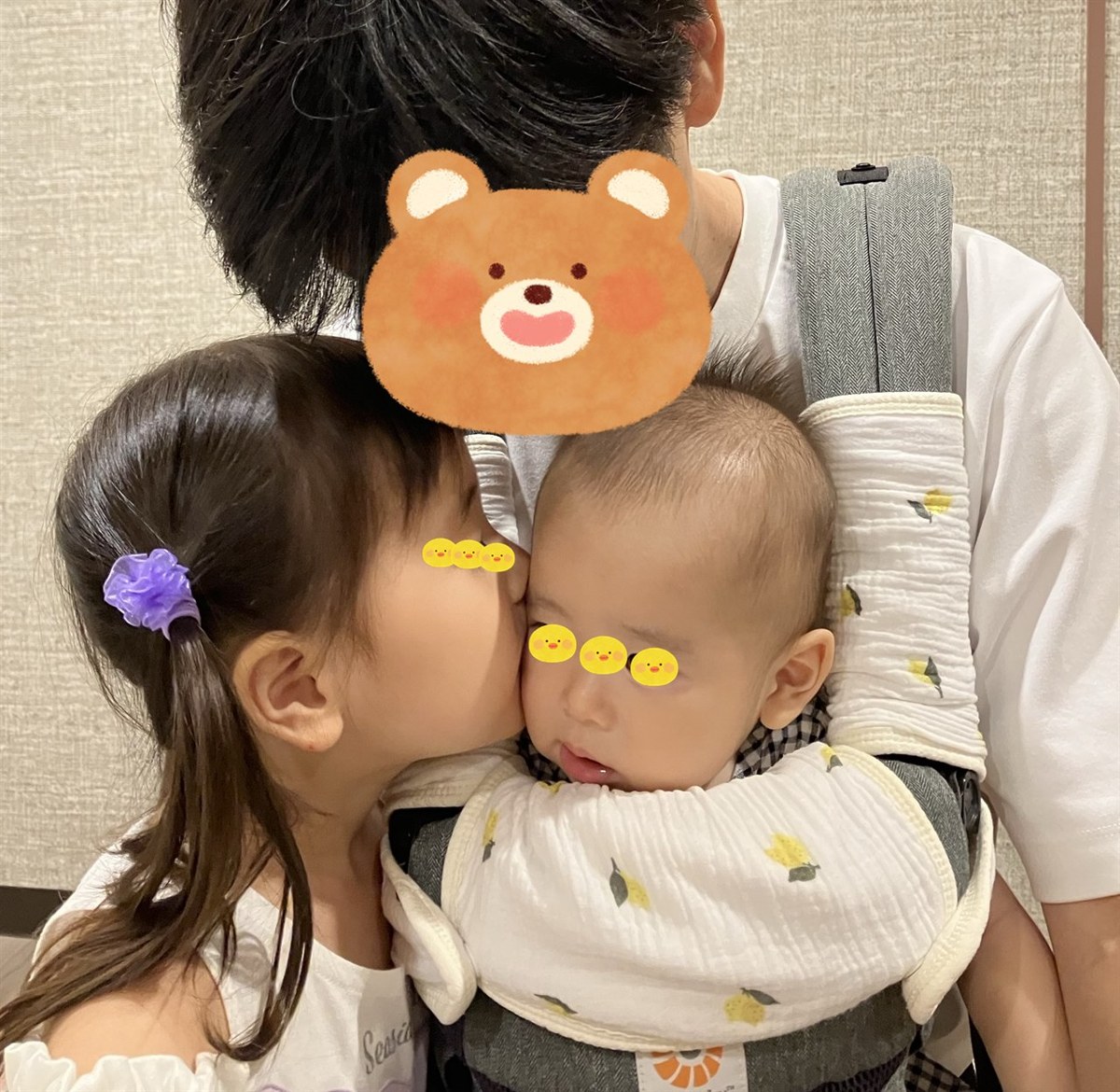 エルゴの肩ひもと前につけた、レモン柄のよだれカバー