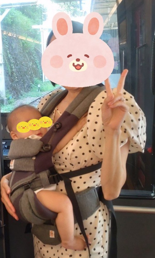 生後6か月の息子を、エルゴの前向き抱っこで抱っこする私(電車の中)