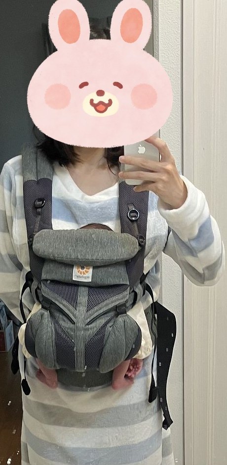 生後10日ほどの息子をエルゴで抱っこした私(前から)。赤ちゃんが小さく、エルゴが大きく見える